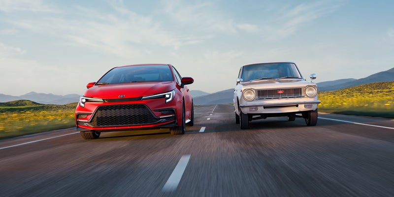 2027 Toyota Corolla 60th Anniversary Special Edition in Supersonic Red driving alongside a 1966 Corolla