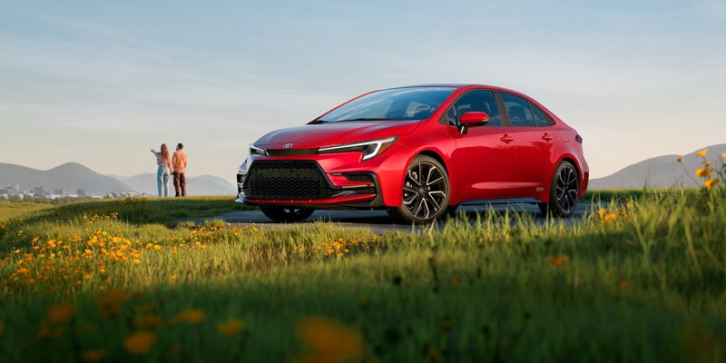 2027 Toyota Corolla sedan driving through Wyoming highway scenery