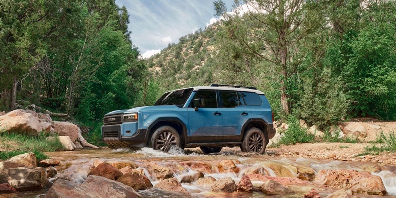 2027 Toyota Land Cruiser navigating rugged mountain trail terrain